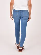 Jean negro de tiro alto, corte chupín, con cinco bolsillos y cierre de botón y cremallera.