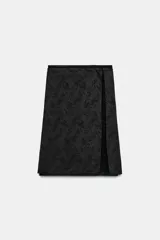 Falda midi de tiro medio en tejido jacquard con diseño floral tono sobre tono. Presenta un corte recto con una abertura lateral y cierre oculto con botón y cremallera.