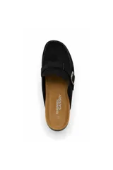 Zueco estilo mocasín negro con acabado efecto gamuza, detalle de hebilla metálica lateral y costuras visibles en el contorno. Cuenta con plantilla anatómica y suela baja.