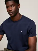 Remera azul marino de corte slim, confeccionada en tejido interlock de algodón elástico. Tiene cuello redondo y logo de Tommy Hilfiger bordado en el pecho.