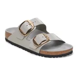 Sandalia Birkenstock modelo Arizona Big Buckle, color gris claro, con dos correas ajustables con hebillas metálicas grandes en tono dorado. Presenta plantilla anatómica de corcho y suela de goma negra.