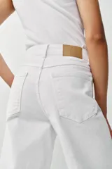 Jeans de tiro alto con diseño de pernera ancha y corte cropped, estilo culotte. Cuenta con cinco bolsillos y cierre frontal con cremallera y botón metálico.