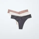 Pack de tres tangas de algodón con cintura de encaje en colores beige, blanco y gris.