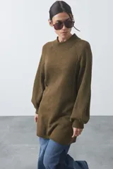 Vestido de punto color verde oliva, con cuello redondo alto, mangas largas con puños ajustados y diseño de silueta relajada.