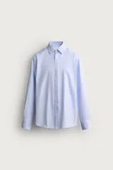 Camisa de corte slim fit, color celeste, con cuello italiano y manga larga con puños abotonados. Presenta un tejido con textura y cierre frontal de botones.
