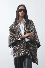 Poncho de silueta amplia con estampado animal print, bordes terminados con costura decorativa y diseño envolvente.