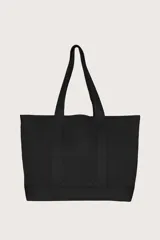 Bolso tote grande color negro con textura acanalada y asas anchas.