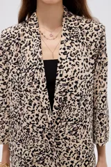 Blazer de viscosa con estampado animal print tipo dálmata en tonos marrones y beige, con cuello solapa y mangas 3/4.