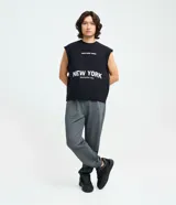 Pantalón tipo jogger de corte holgado, confeccionado en tejido de algodón y poliéster, con cintura elástica ajustable mediante cordón, bolsillos laterales y puños elásticos en el ruedo.