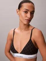 Bralette Calvin Klein de corte triangular, color negro con estampado geométrico de monogramas y banda elástica inferior blanca con el logotipo de la marca. Cuenta con tirantes finos ajustables.