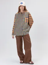 Camisa de viscosa con estampado de rombos en tonos tierra, azul y rojo. Presenta cuello clásico, cierre frontal con botones, bolsillo delantero cuadrado y logo bordado. De corte holgado y manga larga.
