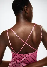 Vestido midi de tejido satinado en color rosado con estampado de lunares marrones. Presenta un diseño recto, cuello escotado y tirantes finos dobles que se cruzan en la espalda abierta.