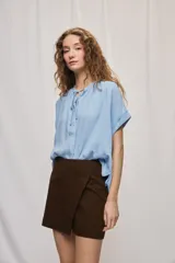 Short cruzado de tiro medio con diseño frontal tipo falda, color negro, de líneas simples y calce cómodo.