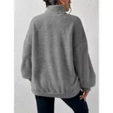 Buzo de polar con textura suave, color beige, con cuello alto y cierre frontal parcial. Diseño de manga larga y calce holgado.