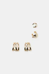 Set de cuatro pendientes metálicos dorados que incluye un par de aros triples con cierre de tuerca, un earcuff de aro doble y un earcuff de aro triple con detalle de cristal.