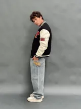 Pantalón de jean estilo baggy de corte ancho y relajado, color azul claro con lavado desgastado. Presenta un bordado en el bolsillo trasero derecho con un diseño de llamas y las siglas SDA.