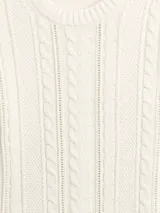 Buzo de algodón color crema con cuello redondo y diseño de punto trenzado en el frente.