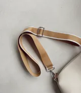 Correa ajustable para cartera, de diseño ancho en color mostaza con bordes en blanco. Incluye herrajes metálicos plateados y ganchos tipo mosquetón para intercambiar fácilmente.