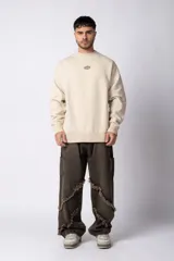 Buzo de cuello redondo y corte oversize, confeccionado en frisa suave. Presenta un diseño minimalista en color negro con un pequeño logo ovalado en el centro del pecho y una estampa sutil en el lateral inferior derecho.