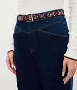 Cinturón femenino angosto de poliuretano color bordó, con doble fila de ojales metálicos, hebilla rectangular plateada y pasador fijo.