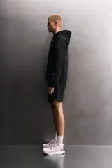 Sudadera de hombre Zara Athleticz de ajuste relajado (relaxed fit), color marrón, confeccionada en tejido técnico compacto con mezcla de algodón y elasticidad. Cuenta con cuello con capucha ajustable con cordones negros, manga larga, bolsillo frontal tipo canguro con un pequeño bolsillo termofijado con cierre, y acabados con rib en puños y cintura.
