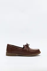 Zapato náutico de cuero sintético color marrón, con cordones decorativos, costuras a la vista y suela de goma antideslizante.
