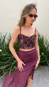 Pollera larga de gasa color bordó, con diseño de tiro alto, base fruncida y tajo lateral profundo decorado con volados verticales.