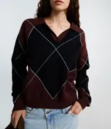 Buzo de tricot con cuello polo y diseño de patrón a cuadros en tonos bordó y negro. Presenta mangas largas y un calce amplio y relajado.