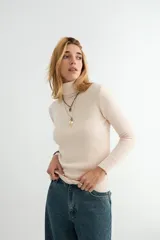Polera de cuello alto y manga larga, confeccionada en tejido de punto fino con puños y ruedo acanalados.