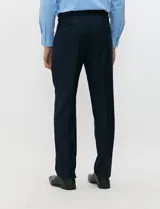 Ambo de doble abotonadura color azul marino, confeccionado en tejido con spandex. Saco de solapas en punta, hombros estructurados y bolsillos con solapa. Pantalón de corte recto con pinza frontal.