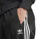 Pantalón deportivo Adidas Beckenbauer color negro con tres rayas blancas a los costados y logo bordado en blanco.