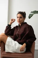 Campera bomber de gamuza con estampado animal print en tono bordó, cierre frontal dorado y puños y cintura de tejido elástico negro.