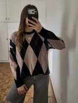 Sweater de tejido bremer doble con patrón de rombos en tonos negro y tostado, cuello redondo y mangas largas.