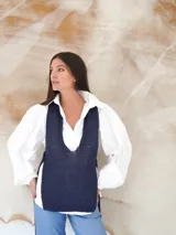 Chaleco de punto azul con escote en U pronunciado y laterales abiertos.