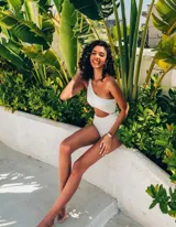 Malla enteriza blanca de un solo hombro con abertura en la cintura.