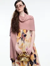 Chal tejido en hilado liviano color rosado con brillo sutil y pequeñas lentejuelas al tono. Diseño envolvente y fluido.