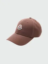 Gorra de baseball Moncler de color marrón, con visera curva, ojales bordados para ventilación y parche con el logo de la marca bordado en el frente.