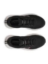 Championes Under Armour Charged Assert 10 para mujer, color negro con entresuela blanca y el logo de la marca en rosado en el lateral. Confeccionados con parte superior de malla transpirable y revestimientos sintéticos.
