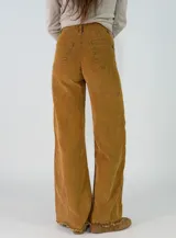 Pantalon de pana de corte recto y tiro medio, con diseño de pierna ancha y ruedo desflecado. Cuenta con cierre frontal y bolsillos laterales.