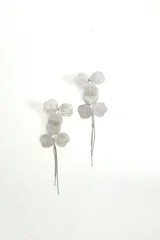 Par de caravanas plateadas con forma de flor de tres pétalos y strass en el centro.