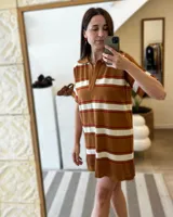 Vestido corto tejido de punto con cuello polo, manga corta y diseño a rayas horizontales en tonos marrón, naranja y blanco.