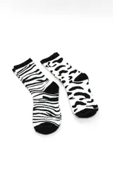 Pack de dos pares de medias crew en color blanco y negro con estampados de animal print, uno con diseño de cebra y otro con diseño de leopardo.