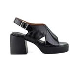 Sandalias negras de cuero charol con plataforma y taco ancho. Presentan tiras cruzadas en el empeine, una tira trasera con hebilla y una sección con textura de piel de reptil.