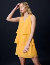 Vestido corto de gasa color amarillo, con escote en V, sin mangas y forro interno a tono.