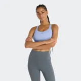 Top deportivo New Balance de entrenamiento con tecnología NB DRY de secado rápido. Presenta un diseño de corte americano con cuello redondo, banda elástica bajo el busto para mayor soporte y copas extraíbles. Incluye logo impreso en el frente.