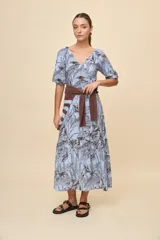 Vestido largo celeste con estampado botánico en tonos marrones, escote en V, mangas cortas abullonadas y falda con volado en el bajo.