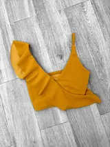 Top de bikini fucsia con un solo tirante y volados en el escote.