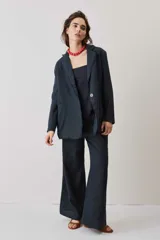 Blazer de lino color azul marino, de corte recto, con solapas y cierre frontal de un botón. Presenta detalles de flecos en los bordes.