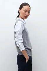 Chaleco de tejido de punto con escote en V y terminaciones acanaladas en cuello y sisas.