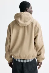 Campera tipo worker de algodón con cierre frontal, capucha con cordón ajustable, bolsillos delanteros abiertos y puños y bajo con elástico.